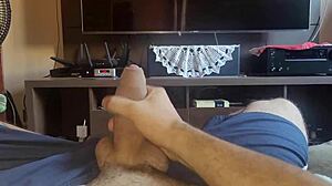 Young gay guy gives a good hand job in the living room.