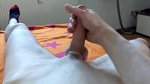Solo gay man masturbates and ejaculates while watching an adult film.